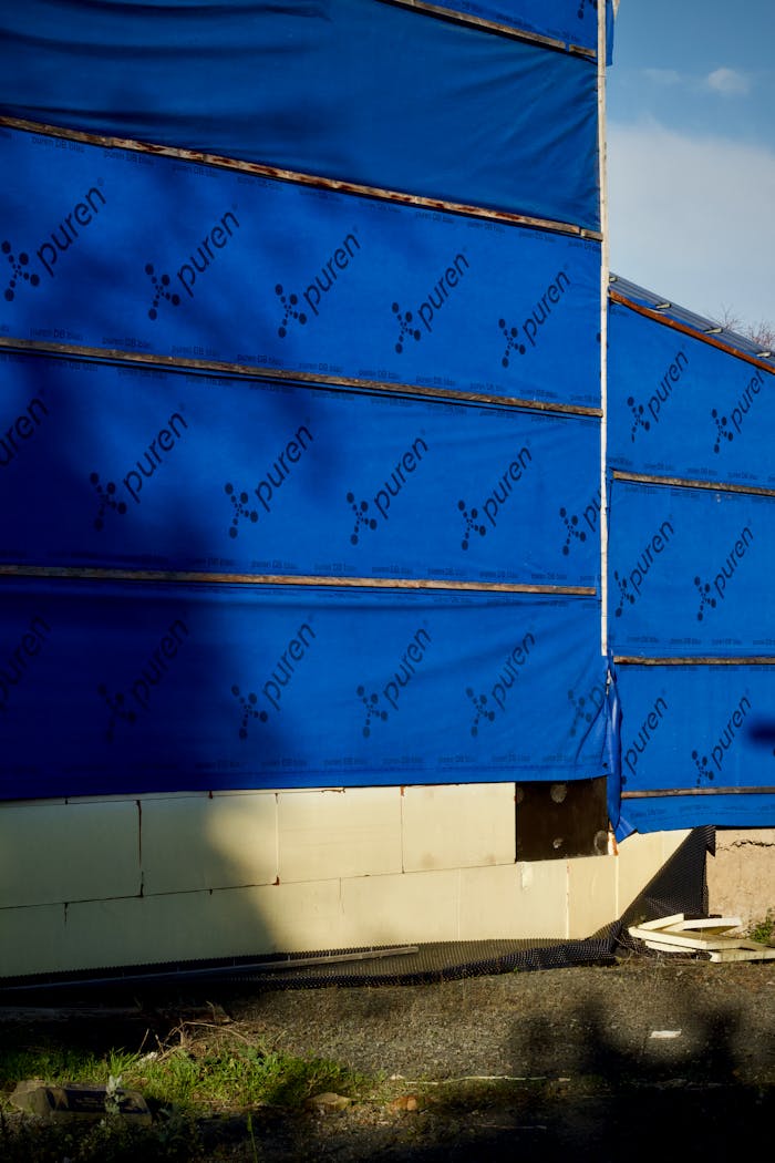 portfolio-02 Building under construction with blue insulating wrap showing brand name puren