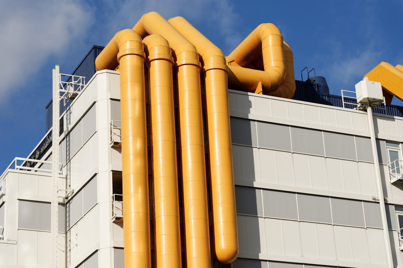 Close-up of a building facade in Rotterdam featuring striking yellow pipes.