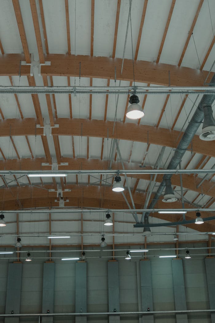Crafting Captivating Headlines: Your awesome post title goes here High-angle view of a spacious industrial ceiling featuring pendant lights and steel design elements.
